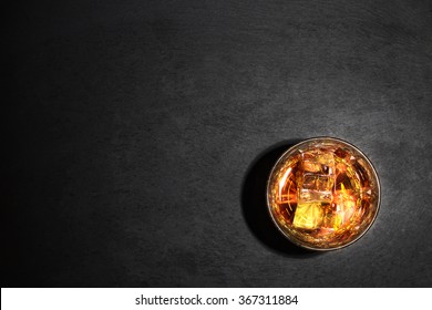 Glass Of Whiskey With Ice On Black Background Shot From Above