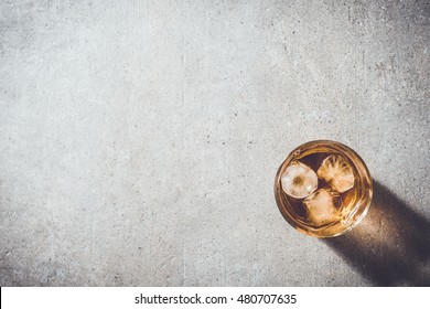 Glass of whiskey on gray stone table
