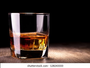 glass with whiskey on wooden table