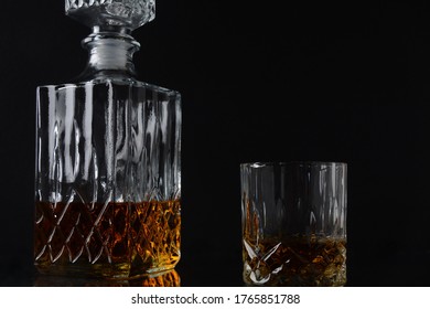 Glass Of The Whiskey And A Square Decanter On A Black  Background.