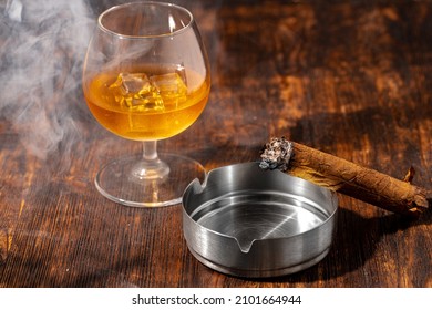 Glass Of Whisky And Lighted Cigar In An Ash Tray