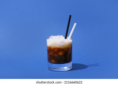 Glass Of White Russian Cocktail On Blue Background