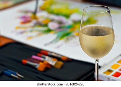 Glass of white wine close up. Wine on a palette background with paints. The concept of creativity and inspiration. - Shutterstock ID 2016824228