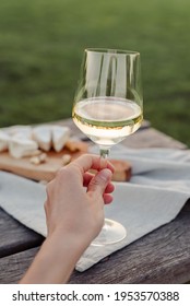 A glass of white wine in female hand.