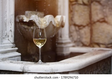 Glass Of White Wine On A Stone Fountain