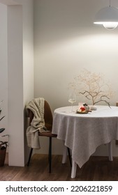 Glass Of White Wine On The Table In The Cozy Evening Light Of The Scandinavian Style Living Room