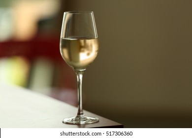 Glass With White Wine On Table