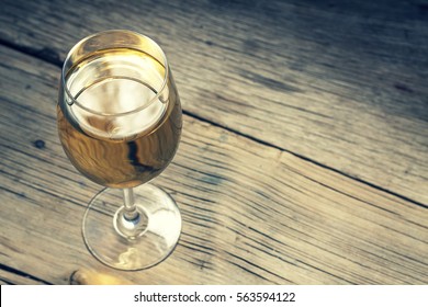 Glass Of White Wine On Vintage Wooden Table