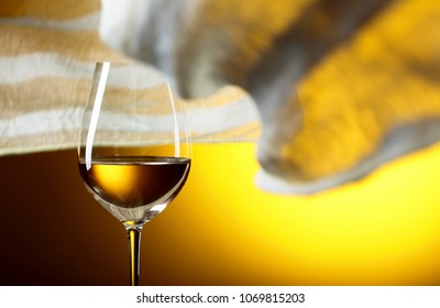 Glass Of White Wine On A Yellow Background. Yellow Sheer Fabric Flutters In The Wind. Copy Space.