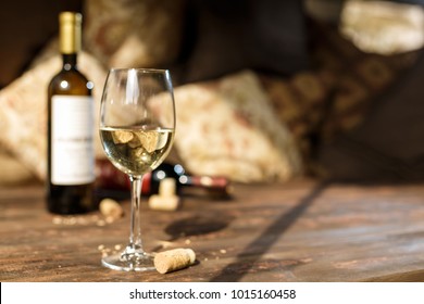 glass of white wine in restaurant wooden table with romantic dim light and cosy atmosphere