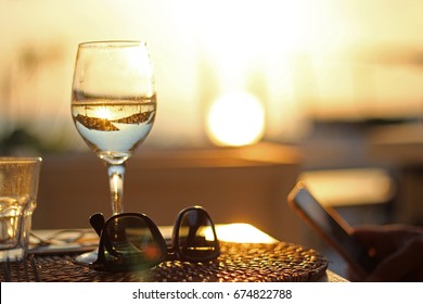 a glass of white wine at sunset