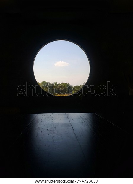 Glass window circle have light inlet on table, \
sky and tree outdoor