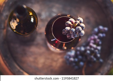 A Glass Of Wine And A Bottle Of Red Wine On A Wooden Barrel, Top View