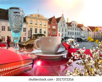 glass of wine cup coffee red walet on table street cafe medieval Tallinn old town spring flowers but  street phot scene travel to Estonia Baltic 