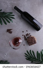 a glass of wine with dark chocolates on the table