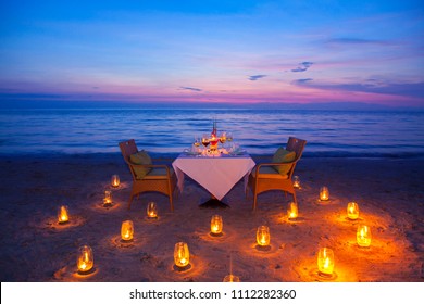  glass of wine And equipment on a wooden table with seascape and skyline in the evening with sunset tone style,Sunset is a romantic candlelight.