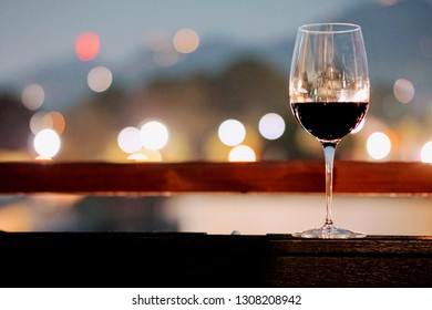 A Glass Of Wine In A Restaurant  Dinning Room Or Rooftop Bar, With Bokeh Background Of The City Light, Good View And Romantic Scene, For Valentine Dating Or Celebrate Special Day, With Copy Space,