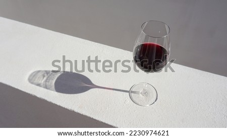A glass of wine with a shadow on a white paint surface background Foto stock © 