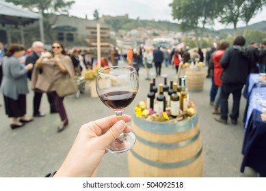 Glass of wine at tasting area of annual city festival Tbilisoba with crowd of people around. Tbilisi, the capital of Georgia country - Shutterstock ID 504092518