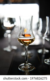 A Glass With Wiskey On Table With Blurred Background. Concept Of Whiskey Tasting.