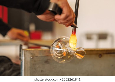 Glassblower shapes the glass in glass-blowing workshop, Murano.  - Powered by Shutterstock