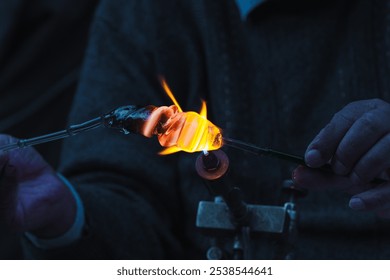 Glassblowing  
A close-up of hands carefully shaping molten glass with fire in a glassblowing process. - Powered by Shutterstock