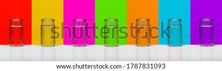 GlassBottle of water on seven colors background