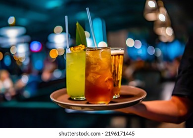 gafas, cóctel de alcohol y cerveza en una bandeja de camarero en el bar