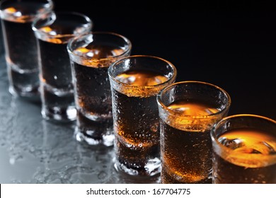 Glasses with an alcoholic drink on a damp glass table