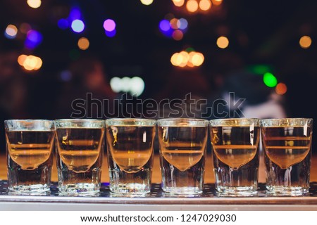 Glasses with an alcoholic drink on a wooden table.