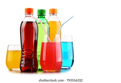 Glasses and bottles of assorted carbonated soft drinks isolated on white
