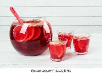 Glasses And Bowl With Aromatic Punch Drink On White Wooden Table