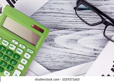 Glasses and calculator on paper table with diagram, copyspace or frame