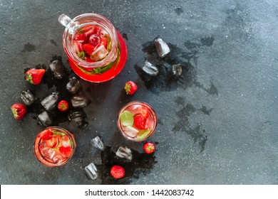 Glasses And Carafe With Organic Strawberry Drink. Refrigerated Refreshing Mixed Ripe Berries And Mint Green Leaves In Vitamin Bio Liquid. Splash Of Water And Ice. Sweet Delicious Beverage Top View