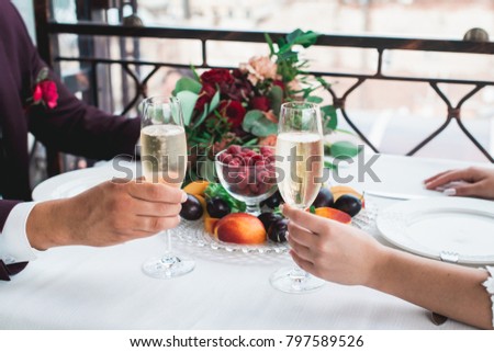 Glasses with champagne drink in bride and groom hands. Happy newlyweds drinking. Loving couple created new family.