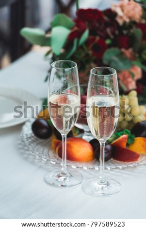 Glasses with champagne drink on a table. Happy newlyweds drinking. Loving couple created new family.