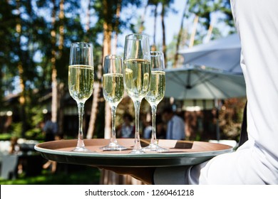 Glasses with champagne on the waiter's trayat a wedding outdor - Powered by Shutterstock