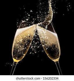 Glasses of champagne with splash, isolated on black