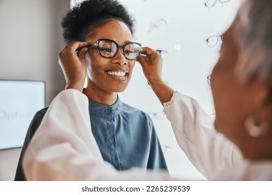 Glasses check, black woman and customer with store worker and optician looking at lense. Eye consulting, smile and eyewear assessment in a frame shop for vision test and prescription exam for eyes