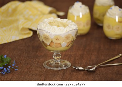 Glasses with delicious banana pudding on table.