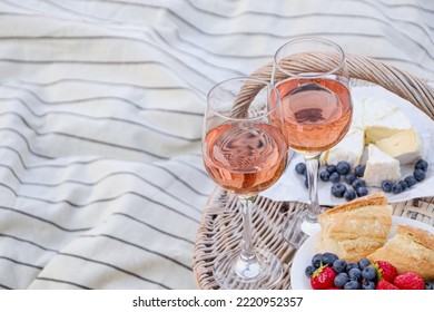 Glasses Of Delicious Rose Wine, Food And Basket On White Picnic Blanket, Space For Text