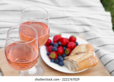 Glasses Of Delicious Rose Wine And Food On White Picnic Blanket, Closeup