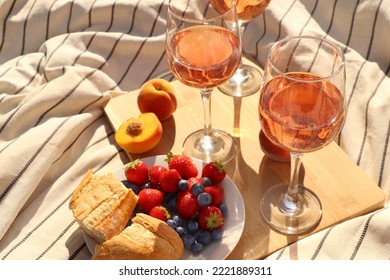 Glasses Of Delicious Rose Wine And Food On White Picnic Blanket