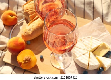 Glasses Of Delicious Rose Wine And Food On White Picnic Blanket