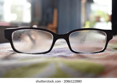 A Glasses With Dirty Lens On Blurred Background