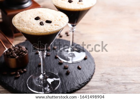 Glasses of fresh coffee cocktail on wooden table. Space for text