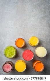 Glasses of fresh juice on gray stone table. Food background