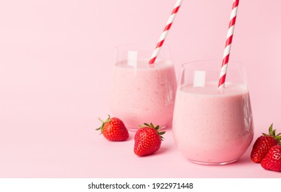 Glasses of fresh strawberry smoothie on a pink background. Summer drink shake, milkshake and refreshment organic concept.