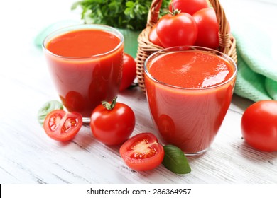 Glasses of fresh tomato juice on wooden table, closeup
