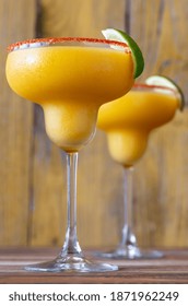 Glasses Of Frozen Mango Margarita Cocktails Garnished With Paprika Salt Rim